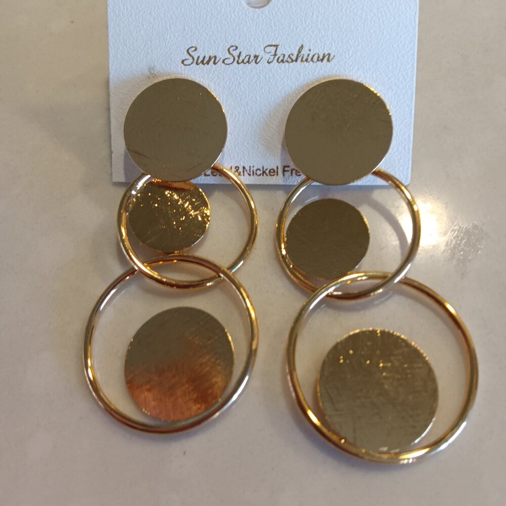 A pair of contemporary triple circle earrings in both silver and gold tone metal